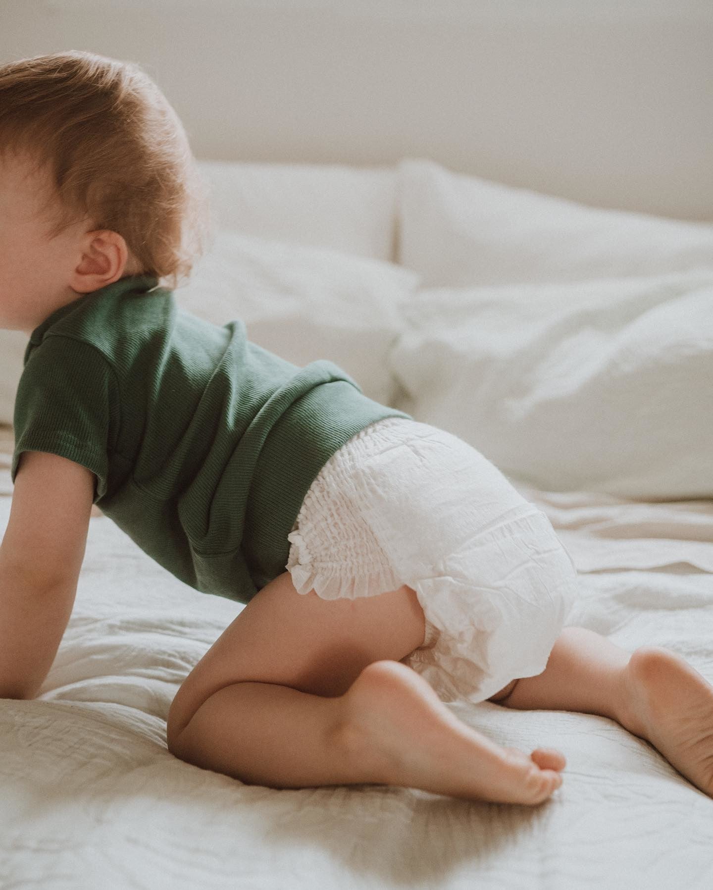 baby crawling on bed with Ecoriginals nappy